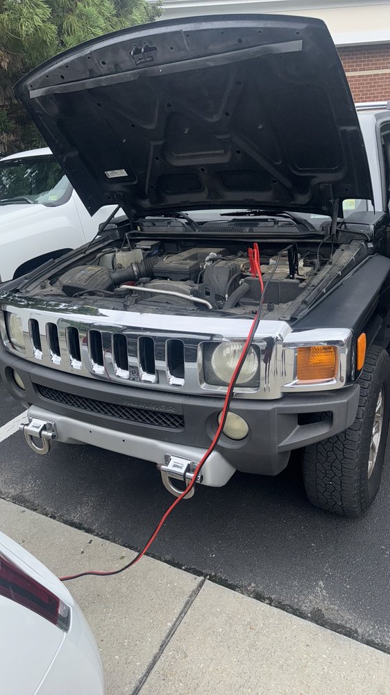 Battery assistance with jumper cables connected under the hood of a Hummer H3